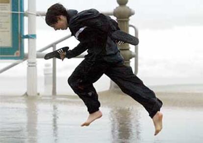 Un muchacho corre contra el viento en el paseo marítimo de Virginia Beach, cerca de Washington.