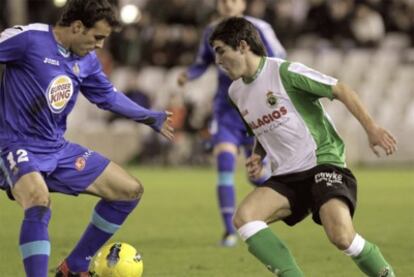 Racing's Jairo Samperio tangles with Getafe midfielder Pedro León.