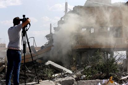 Un càmera grava les ruïnes d'uns dels centres d'investigació atacats pels EUA.