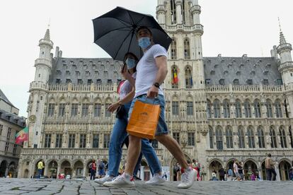 Una pareja pasea por el centro de Bruselas con mascarilla.