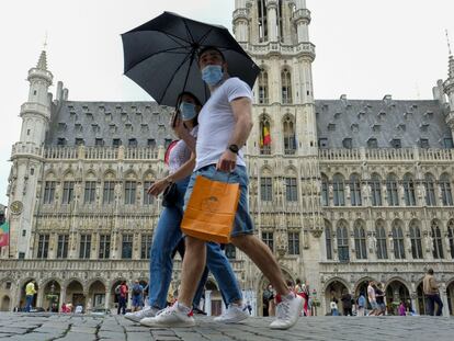 Una pareja pasea por el centro de Bruselas con mascarilla.