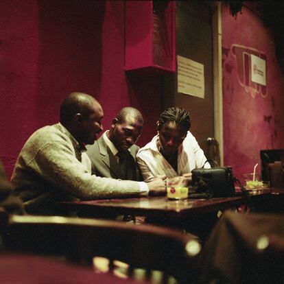 <p>Chema Castelló (Madrid,1965) es fotógrafo profesional, así que a menudo lleva su cámara Hasselblad cuando sale. En una de esas ocasiones asistía un recital de poesía de su hermano, Julio Castelló, en un café de Madrid ubicado en la calle Regueros. Allí tomaría la imagen que le valdría el primer premio del concurso en su primera edición, en 2013: ‘Tida & Co’. “Es una instantánea, no eran conscientes de ser observados. Me pareció una bella escena de camaradería, inmersa en colores y luces como de jazz. A veces los fotógrafos jugamos a cineastas...”, asegura Castelló.</p> <p>La protagonista de la imagen es Tida Coly y el fotógrafo la conoce muy bien porque se trata de su cuñada. “Llegó a nuestra familia en 2001 y fue como si se abriera una ventana del castillo Castelló. La adoramos, es sencillamente maravillosa; hermana de ley, pero de verdad”. Los acompañantes de Tida son dos de sus amigos, Mounir y Tafsir, a los que conoció en España.</p> <p>Dice Castelló que sobre Tida se podría escribir más de un libro: “Uno sobre emprendimiento y superación, pero también otro de esos de autoayuda, basándose en su sentido de la vida y su generosidad de ánimo y de alma”. Senegalesa de nacimiento, Tida Coly reside en España desde hace 18 años. Ha trabajado en varios sectores, desde la hostelería hasta en un banco, pasando por azafata de congresos. “Hoy es una de las pocas mujeres negras emprendedoras en España y es considerada un referente”, abunda el autor de la fotografía. En la actualidad, es directora de su propio negocio: Tida Coly Colores del Mundo. Se trata de una tienda ubicada en San Lorenzo del Escorial en la que ofrece telas, artesanías, diseños y hasta eventos culturales. “La empresa representa un puente de mestizaje cultural entre el África negra y España. ¿No es para estar orgulloso?”, presume Castelló.</p> <p>Chema Castelló trabaja desde hace 30 años como artista visual, fotógrafo y diseñador especializado en arquitectura, artes y retrato. Cuenta con varias exposiciones a sus espaldas en importantes lugares como la Feria ARCO'13, Espacio Fundación Telefónica y el festival Photoespaña, por citar algunos. Entre sus clientes se encuentra la Fundación Telefónica o TVE. </p>