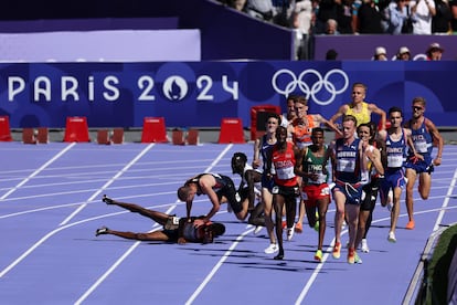 El español Thierry Ndikumwenayo y el británico George Millstropiezan y caen durante la primera ronda de la prueba de 5000 metros.