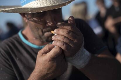 Un mariscador se enciende un cigarrillo al finalizar el despesque en los esteros del Carrascón en San Fernando, Cádiz.