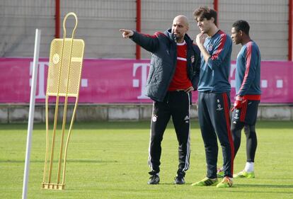 El entrenador del Bayern de Múnich, el español Pep Guardiola (i), da instrucciones a los jugadores Javi Martinez (c) y David Alaba durante una sesión de entrenamiento celebrada en el complejo deportivo de Saebener Strasse, en Múnich (Alemania) hoy, martes 18 de febrero de 2014. El Arsenal recibe este miércoles al Bayern de Múnich dispuesto a mantener en la Liga de Campeones el momento dulce que atraviesa esta temporada en Inglaterra, donde es uno de los favoritos para hacerse con la Premier tras varios años fuera de la carrera por el título.