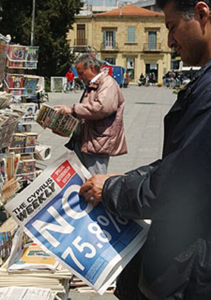 Grecochipriotas vecinos de Nicosia hojean la reacción de la prensa.