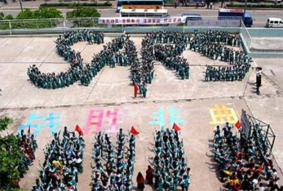 Decenas de escolares componen las siglas SARS en una campaña contra el mal en Nanjing.