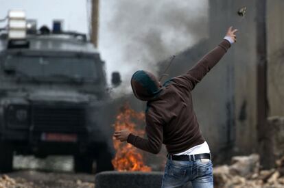 Un manifestante palestino arroja una piedra contra las fuerzas de seguridad israelíes durante enfrentamientos tras una manifestación cerca de Nablus, en la Cisjordania ocupada.