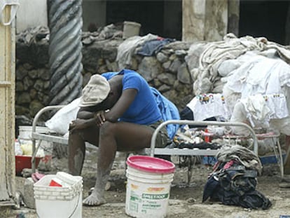 Una mujer descansa sentada en una cama en una calle de Gonaives, al noroeste de Haití.