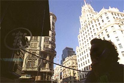 Un usuario habla desde una cabina de Telefónica frente al edificio de la empresa en la Gran Vía de Madrid.