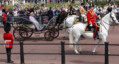 Isabel II, con un elegante vestido color lila y un sombrero del mismo color con trazos amarillos y verdes, saluda a sus súbditos en el que es considerado el evento más celebrado del calendario real británico