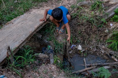 Un niño juega en el caño por el que pasan las aguas fecales de uno de los asentamientos de Tibú, la frontera colombiana con Venezuela.