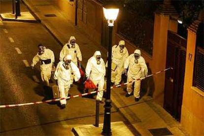 Técnicos con trajes de protección NBQ inspeccionan la calle en la que se produjo el escape de ácido cianhídrico.