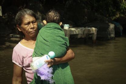 Una mujer de la comunidad La Montañita se dirige a lavar su ropa y aprovecha a bañar a su nieto en la orilla frente a la Isla Filipinas, Granada.
