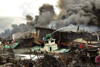Trabajadores de Indonesia y los bomberos intentan extinguir un incendio en los barcos de pesca, en el puerto de Benoa en Denpasar, en la isla turística de Bali. 
