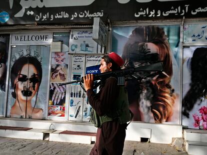 Un talibán pasa por delante de un salón de belleza con las imágenes de mujeres tachadas con aerosol, en Kabul este 18 de agosto.