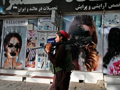 Un talibán pasa por delante de un salón de belleza con las imágenes de mujeres pintadas con aerosol, en Kabul, el pasado 18 de agosto.