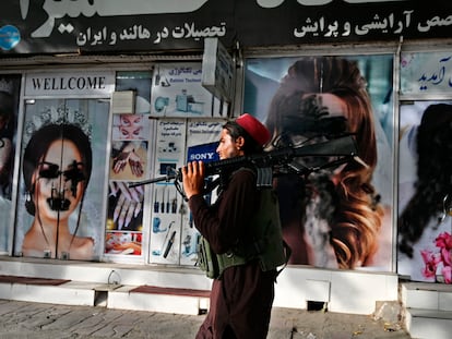 Un talibán pasa por delante de un salón de belleza con las imágenes de mujeres tachadas con aerosol, en Kabul este 18 de agosto.