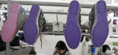 Una mujer trabaja en un taller de zapatería en Hanoi, Vietnam.