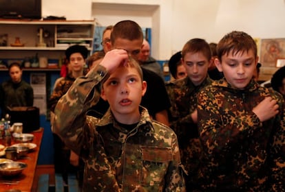 Un grupo de alumnos de la escuela reza antes de sentarse a comer.