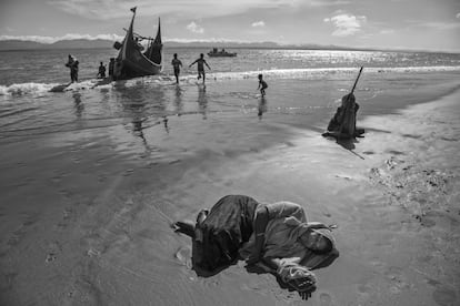 Una mujer refugiada rohingya descansa, exhausta, en la playa después de llegar en barco a la orilla bangladesí del río Naf, en Shah Porir Dwip, después de huir de su aldea en Myanmar.