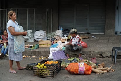 Dos mujeres vendiendo hierbas y fruta en el Mercado 4 de Asunción.