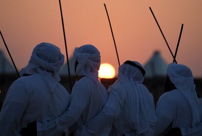 Hombres con trajes tradicionales realizan un baile durante el festival de Dalma en la isla de Dalma, en los Emiratos Árabes Unidos.