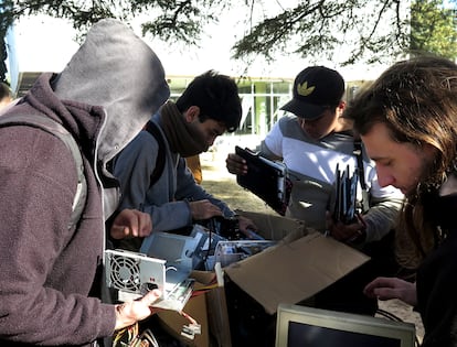 Cuatro hombres buscan entre las cajas de 'residuos cibernéticos' algunas piezas a las que les puedan dar un segundo uso.