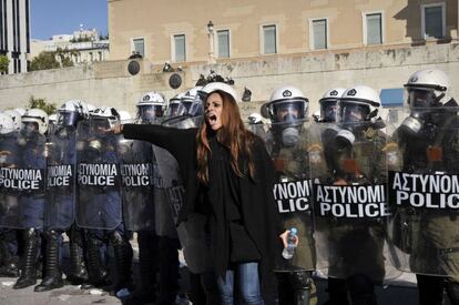 Una mujer pide calma a los manifestantes, justo enfrente de la línea de antidisturbios que protege el Parlamento griego.