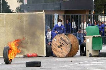 Trabajadores de los astilleros de San Fernando se atrincheraron ayer en las puertas de la factoría, desde donde se enfrentaron a la policía.