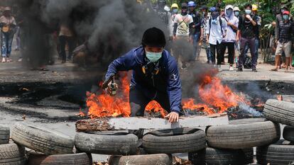 Un manifestante tras una barricada formada en las protestas en Yangon (Myanmar), este sábado.
