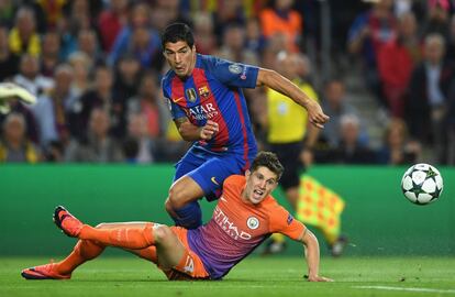 John Stones, del Manchester City, a terra, rep la pressió de Luis Suárez.