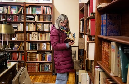 La propietaria de La Galatea, Begoña Ripoll, pasa las hojas de un libro mientras hace cajas para desalojar el local.