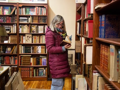 La propietaria de La Galatea, Begoña Ripoll, pasa las hojas de un libro mientras hace cajas para desalojar el local.