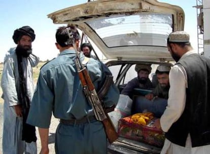 Un policía afgano inspecciona un coche en un puesto de control en Sangin, en la provincia de Helmand.
