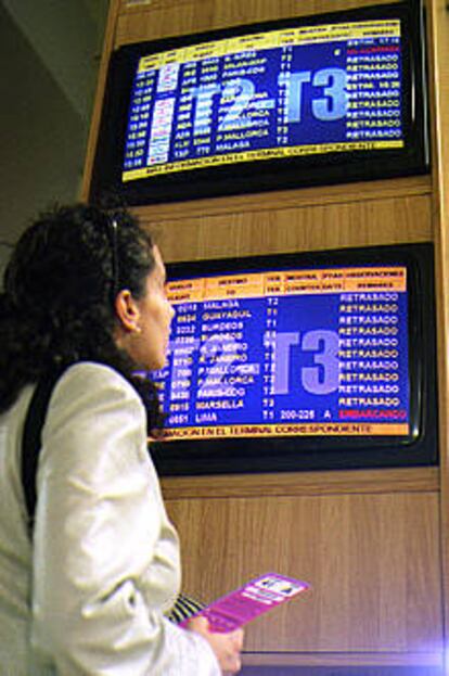 Una pasajera observa los anuncios de retrasos en Barajas.
