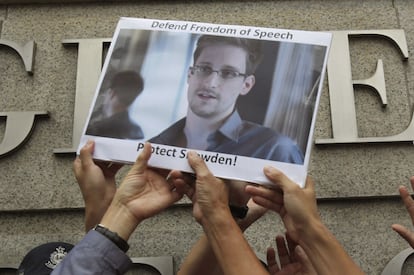 Um grupo de manifestantes segura uma foto do analista de informática Edward Snowden diante do consulado dos EUA em Hong Kong no dia 13 de junho. Dez dias mais tarde, o ex-funcionário da Agência de Segurança Nacional norte-americana voou apara Moscou, onde permanece até agora. Snowden, que filtrou informação do programa de espionagem de seu país, se converteu em um ícone da rebeldia civil ante o poder na era das potentes -e vulneráveis- novas tecnologias da informação.