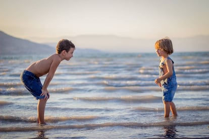 Dos hermanos juegan en la playa. 