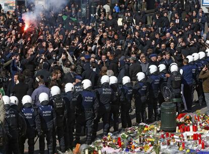 Cordón policial para retener a los radicales que han irrumpido en la concentración por las víctimas de los atentados en la plaza de la Bolsa de Bruselas.