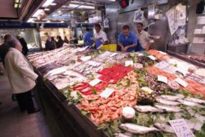 Una mujer realiza sus compras en la pescadería de un mercado madrileño. EFE/Archivo