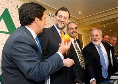 Rajoy, ayer, junto al presidente de Asaja, Pedro Barato (izquierda), durante la junta general de esa asociación.