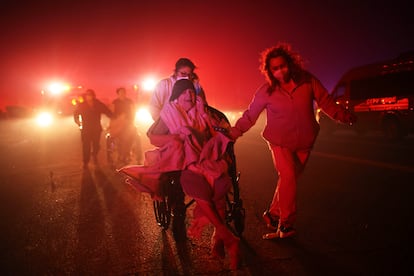 Varios residentes de un centro de mayores son evacuados ante el avance de las llamas, este lunes en Altadena (California).