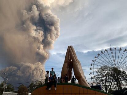 La Cruz Roja filipina ha desplazado a parte de su personal a la zona para ayudar con las labores de evacuación. En la imagen, un grupo de personas observa la erupción del volcán Taal desde Tagaytay.