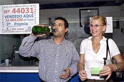 David Gil, lotero de Las Palmas, y una compradora del segundo premio, Brigitte García, celebran el premio.