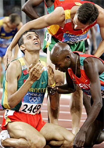 Hicham el Guerruj, arrodillado, ojos al cielo, recibe las felicitaciones de sus escoltas en el podio: Bernard Lagat y (de pie) Rui Silva.