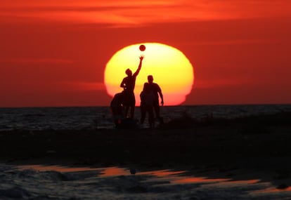 Varias personas juegan con una pelota en una playa del Mar Negro en Vitino (Crimea), el 25 de agosto de 2018.