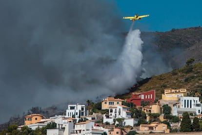 Una avioneta realiza una descarga de agua sobre las llamas que avanzan hacia una zona de viviendas en la Atzubia.