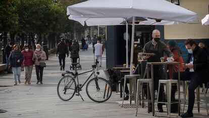 Un camarero atiende una mesa en un bar de Sevilla.