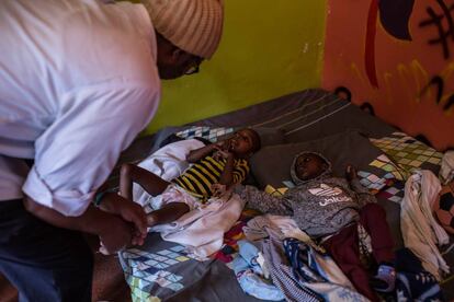 Dennis Mandere, fisioterapeuta, observa a Maiyan Gachuhi y Brian Kamay. Ambos sufren parálisis celebral. Reciben dos sesiones semanales de rehabilitación gratuitas en el centro de día para niños con discapacidad en Mathare, suburbio de Nairobi.