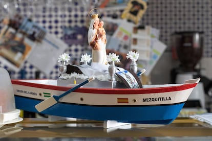 La maqueta de una chalana, embarcación tradicional utilizada hasta hace no demasiado para la pesca, que lleva la imagen de la Virgen del Carmen en un bar de Mezquitilla.